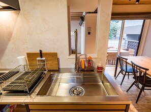 Kitchen features a stainless steel sink, wooden countertop, and metal utensil racks.