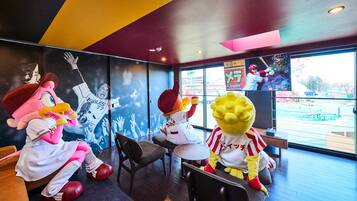 A restaurant interior with mascot characters, a large window, and a poster on the wall.