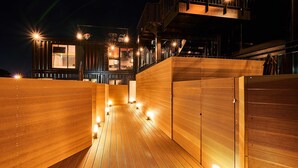 Un edificio moderno con terraza de madera y varios niveles.