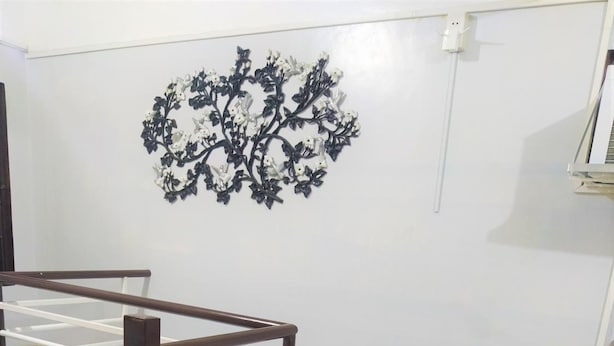 Un dormitorio con una cama, un radiador y un adorno en la pared.