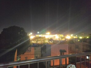 A nighttime view of a building with multiple illuminated sections, surrounded by other structures. - JB Valdres Apartment (Parañaque)