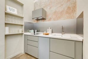 A modern kitchen with a white countertop, two sinks, a stainless steel faucet, and a built-in oven.