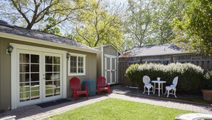 A backyard with a patio, two red Adirondack chairs, a small table, and a white fence. - Private Willow Glen Studio Guesthouse (San Jose)