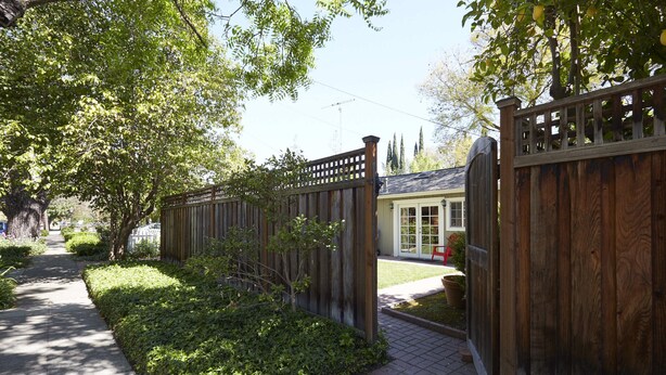 A wooden fence with a lattice design, a paved pathway, and a house with a light-colored exterior. - Private Willow Glen Studio Guesthouse (San Jose)