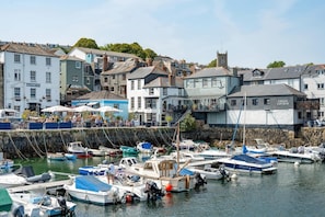 A marina with various boats docked, surrounded by buildings including a hotel and a marine hotel.
