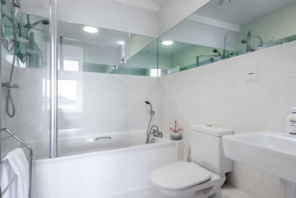 A modern bathroom with a glass-enclosed shower, a white toilet, and a sink. - Bright Flat with Estuary Views & Parking, Falmouth (Falmouth)
