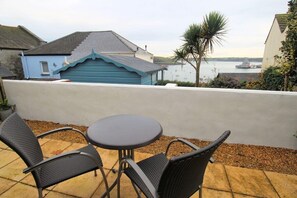A patio with two chairs and a table, overlooking a body of water and a distant ship. - Bright Flat with Estuary Views & Parking, Falmouth (Falmouth)