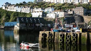 A coastal town with houses on a hillside, a dock with boats, and a building labeled "AQUARIUM". - Gin O'Clock, Mevagissey, Level Walk to Harbour! (Mevagissey)