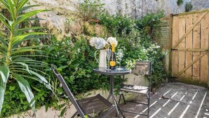 A small outdoor patio with a metal table, two chairs, and a bottle of champagne. - Gin O'Clock, Mevagissey, Level Walk to Harbour! (Mevagissey)