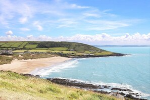 A coastal landscape with a beach, rolling hills, and a clear sky. - Spacious House Large Patio & Free Parking (Barnstaple)