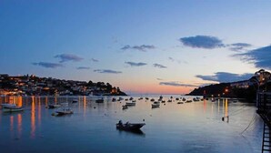 A coastal town at dusk with boats in the harbor and buildings along the shore. - Sundance Cottage, Central Fowey with Sea Views! (Cornwall)