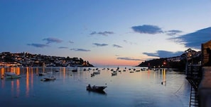 A coastal town at dusk with boats in the harbor and buildings along the shore. - Sundance Cottage, Central Fowey with Sea Views! (Cornwall)