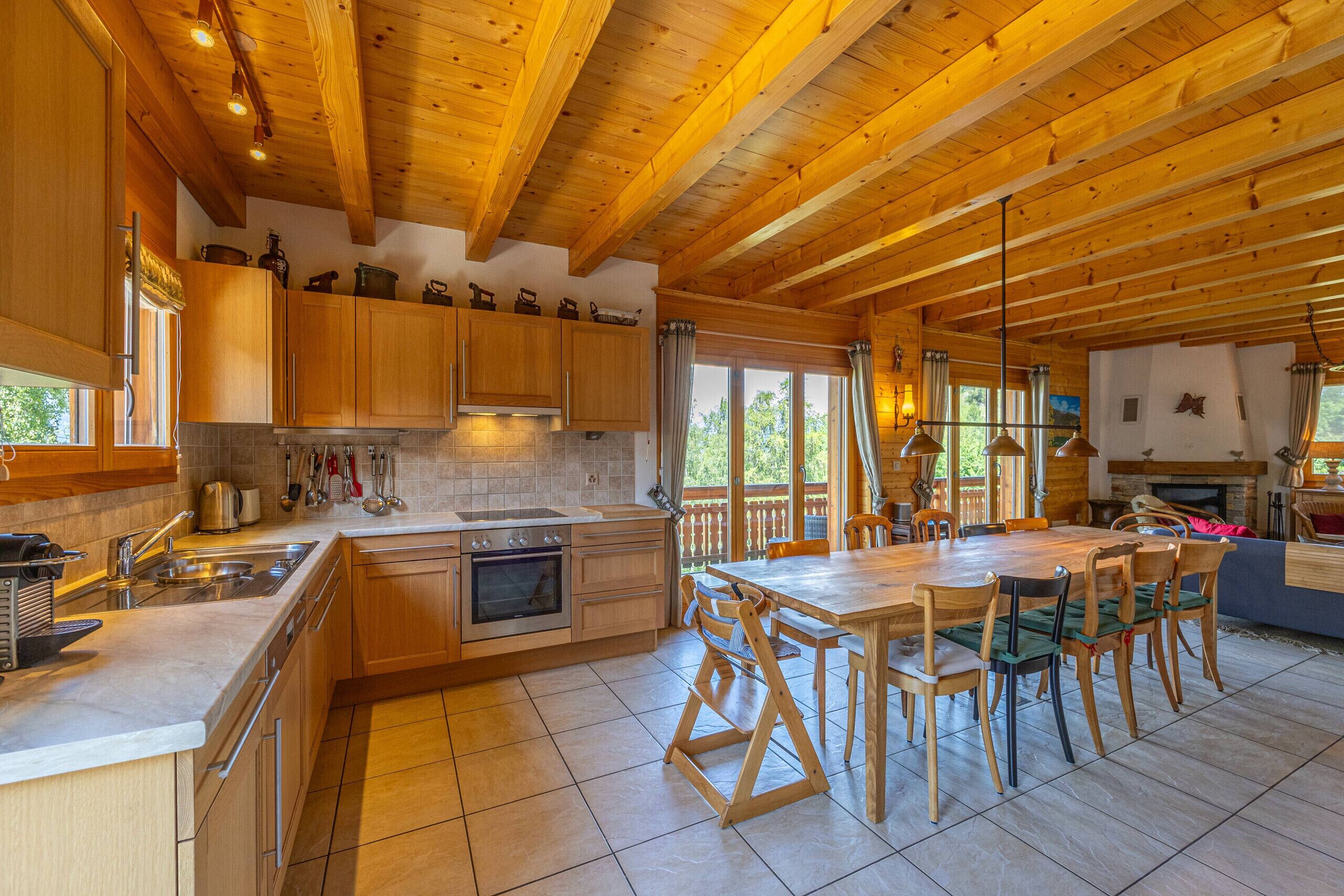 A spacious kitchen with wooden cabinets, a large island, and a dining area with chairs.
