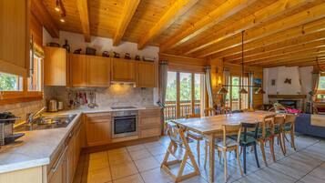 A spacious kitchen with wooden cabinets, a large island, and a dining area with chairs.