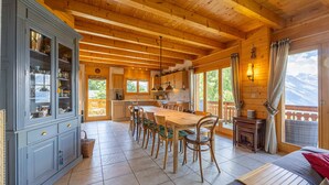 A spacious wooden cabin with a large dining area, kitchen, and a cozy living room with a view of the mountains. - Chalet Le Papillon, sauna, 4 Vallées (Haute-Nendaz)