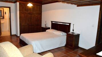A bedroom with a wooden bed, a nightstand, a chair, and a wooden ceiling.