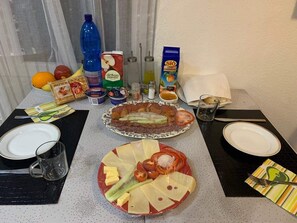 Una mesa servida con platos de comida, salsas y bebidas.