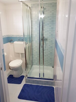 Un baño con ducha acristalada, inodoro y bañera.