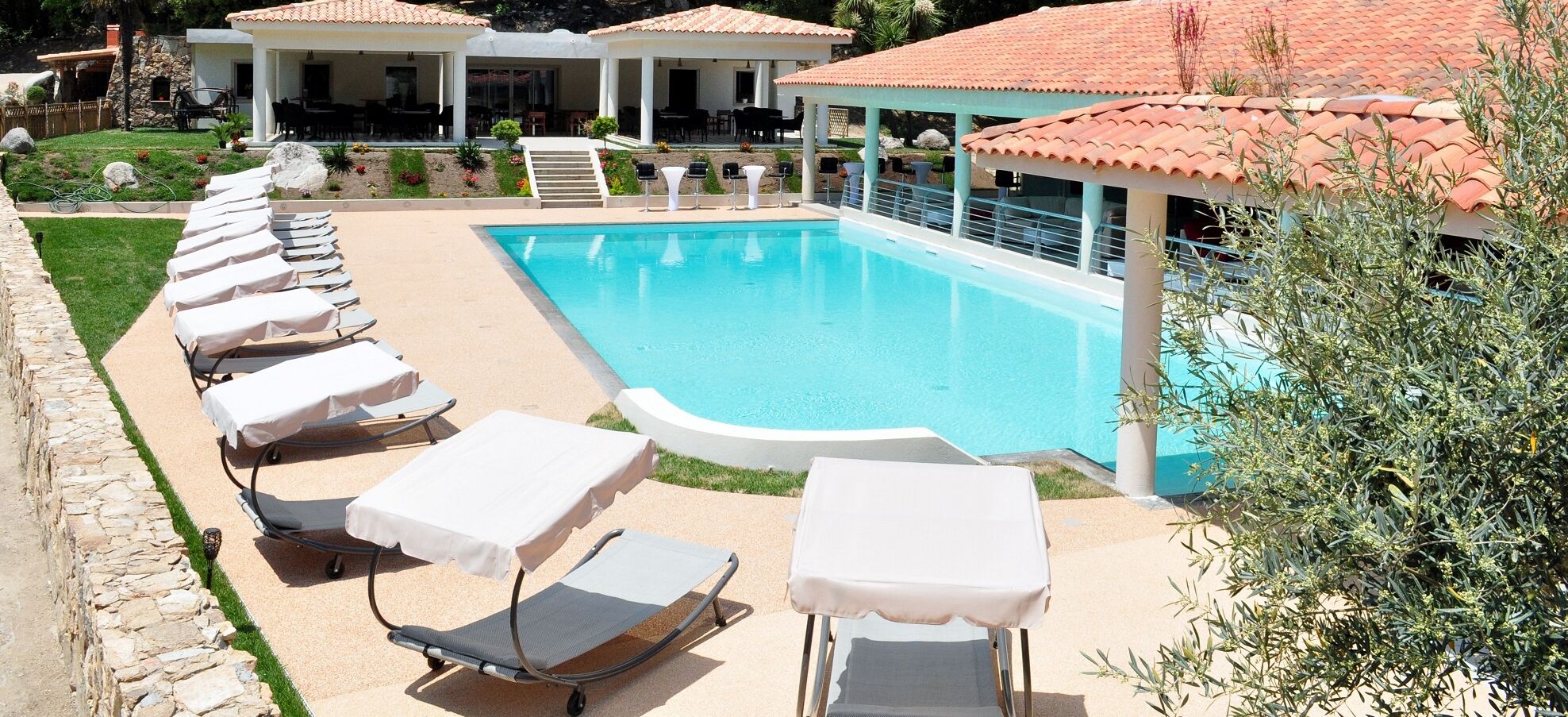 A poolside area with lounge chairs and a swimming pool.