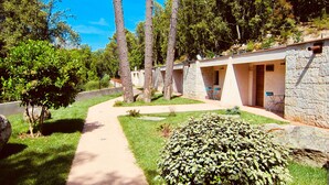 A pathway leading to a row of stone buildings with outdoor seating.