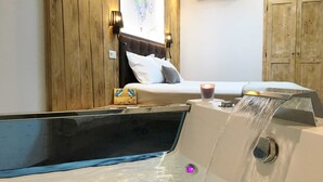 A bedroom with a bed, a wooden wall, a nightstand, a candle, and a water feature.