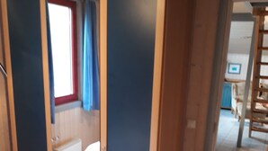 Une chambre avec un lit, une armoire et une fenêtre avec des rideaux.