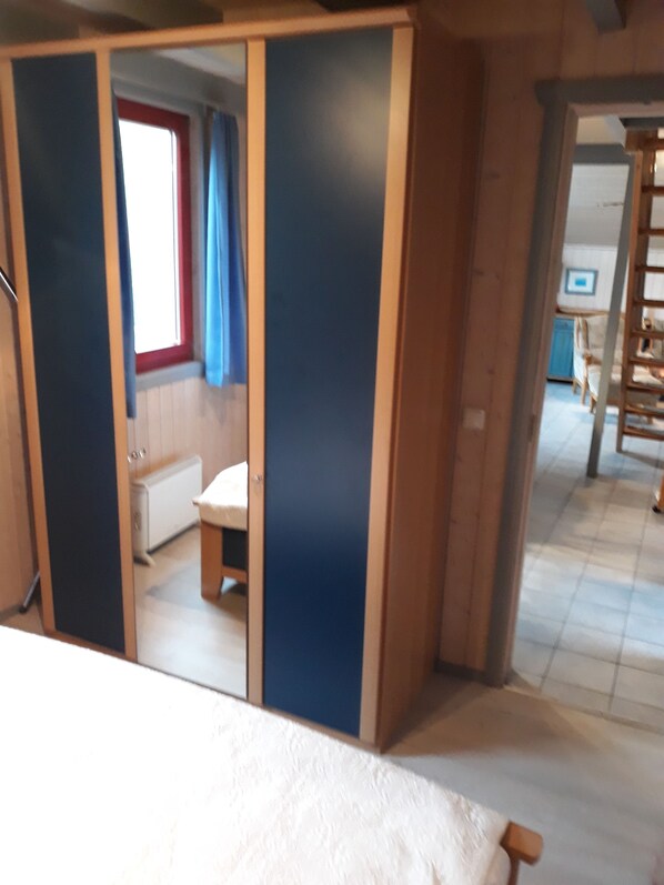 A room with a bed, a wardrobe, and a window with curtains. - Comfortable holiday home with sauna (Mirow)