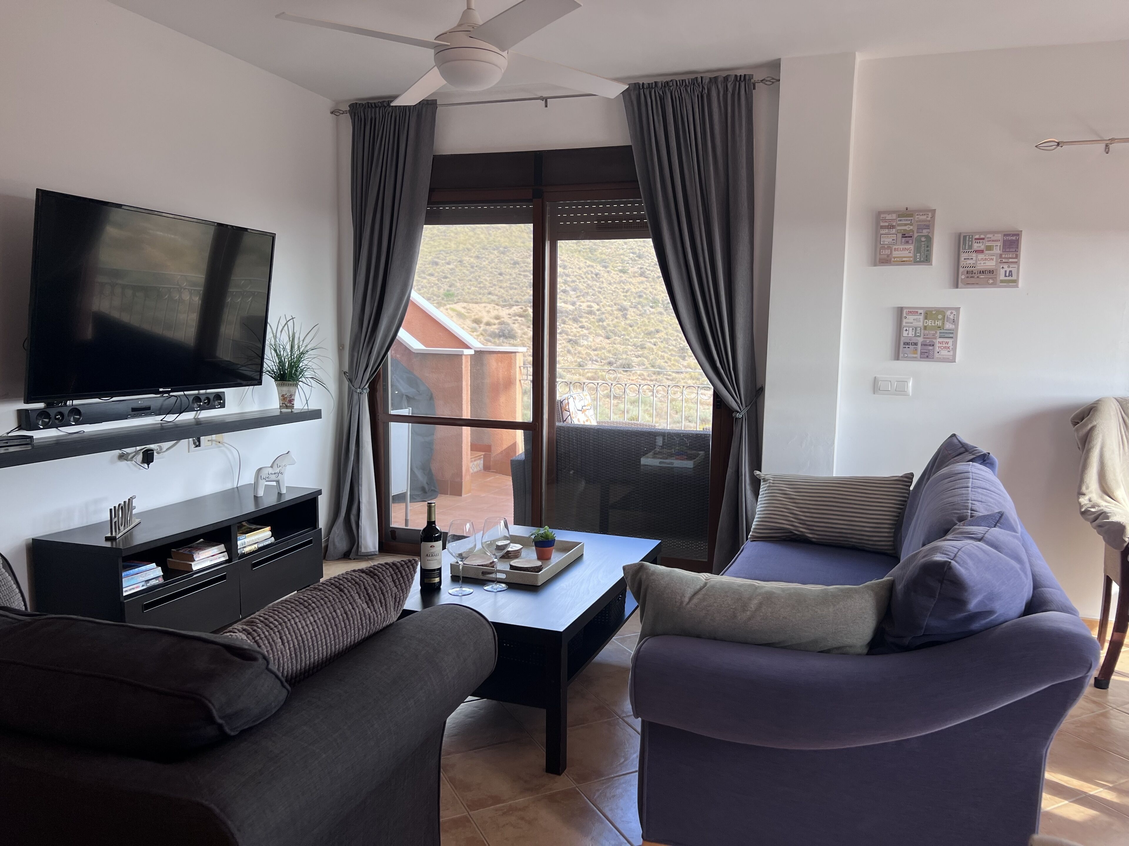 Un salon équipé d’un téléviseur à écran plat, d’un canapé, d’une table basse et d’un balcon avec vue.