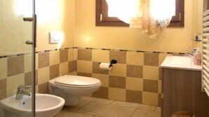 A bathroom with a toilet, bidet, sink, and a mirror. - Autumn Apartment (Agriturismo Il Melograno) (Venezia)