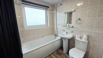 Un baño moderno con bañera, lavabo e inodoro.