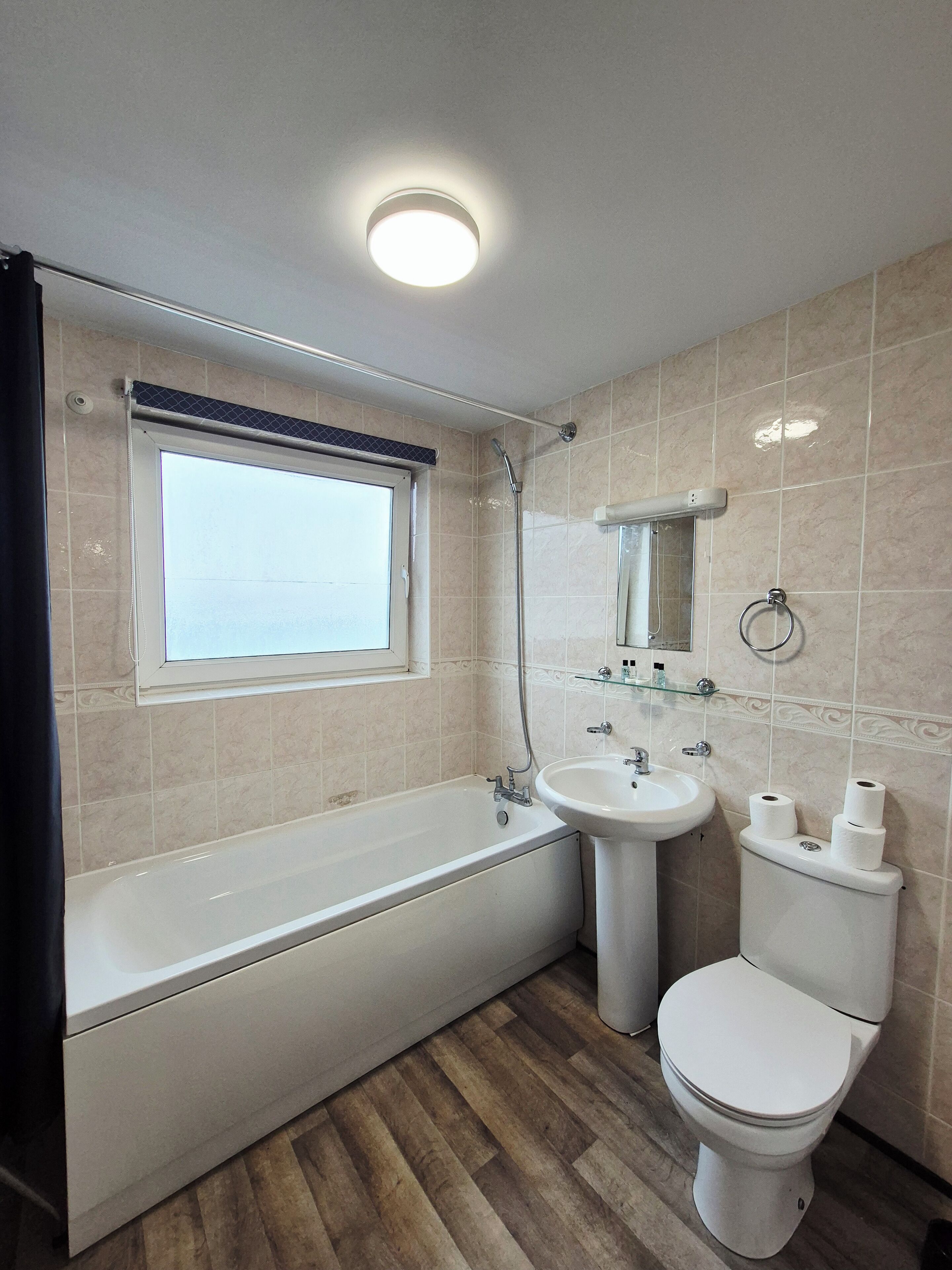 Et moderne badeværelse med badekar, håndvask og toilet.