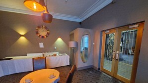 A hotel room with a dining area, a large mirror, and a patterned floor. - OYO Ivy Hotel (Skegness)