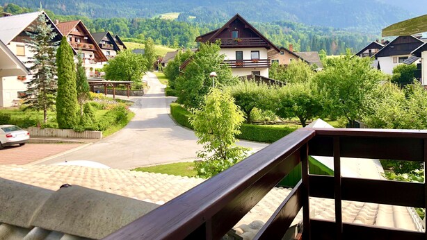 A residential area with houses, a paved road, and mountains in the background. - Apartments Green Paradise D&S (Bohinj)