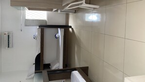 A hotel room with a bed, a wooden cabinet, and a tiled wall. - Pousada universitária (Teresina)
