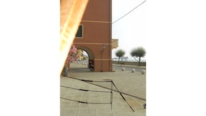 A paved walkway with a metal barrier, a building with an archway, and a parked scooter. - Rio Marina studio apartment in a characteristic residence 10 meters from the sea (Rio Marina)