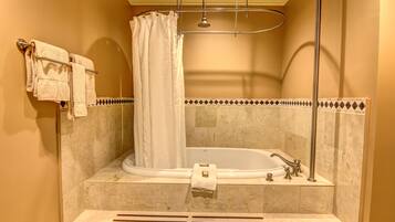 A bathroom with a bathtub, a shower curtain, and a towel rack with towels.