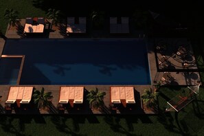 An aerial view of a modern pool area with lounge chairs and a sun terrace.