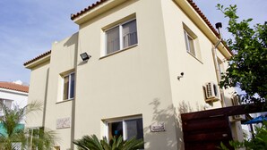 A two-story building with a flat roof, multiple windows, and a door. - The Carolyn villa in Ayia Napa has everything you need for an enjoyable holiday (AYIA NAPA)