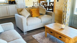 A cozy living room with a sofa, a wooden coffee table, and a rug.