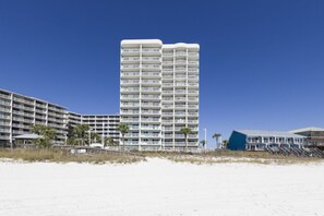 Un hotel de varios pisos con balcones, cerca de una playa.