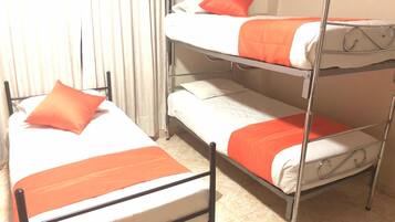 Habitación con literas, dos camas, cada una con ropa de cama naranja.