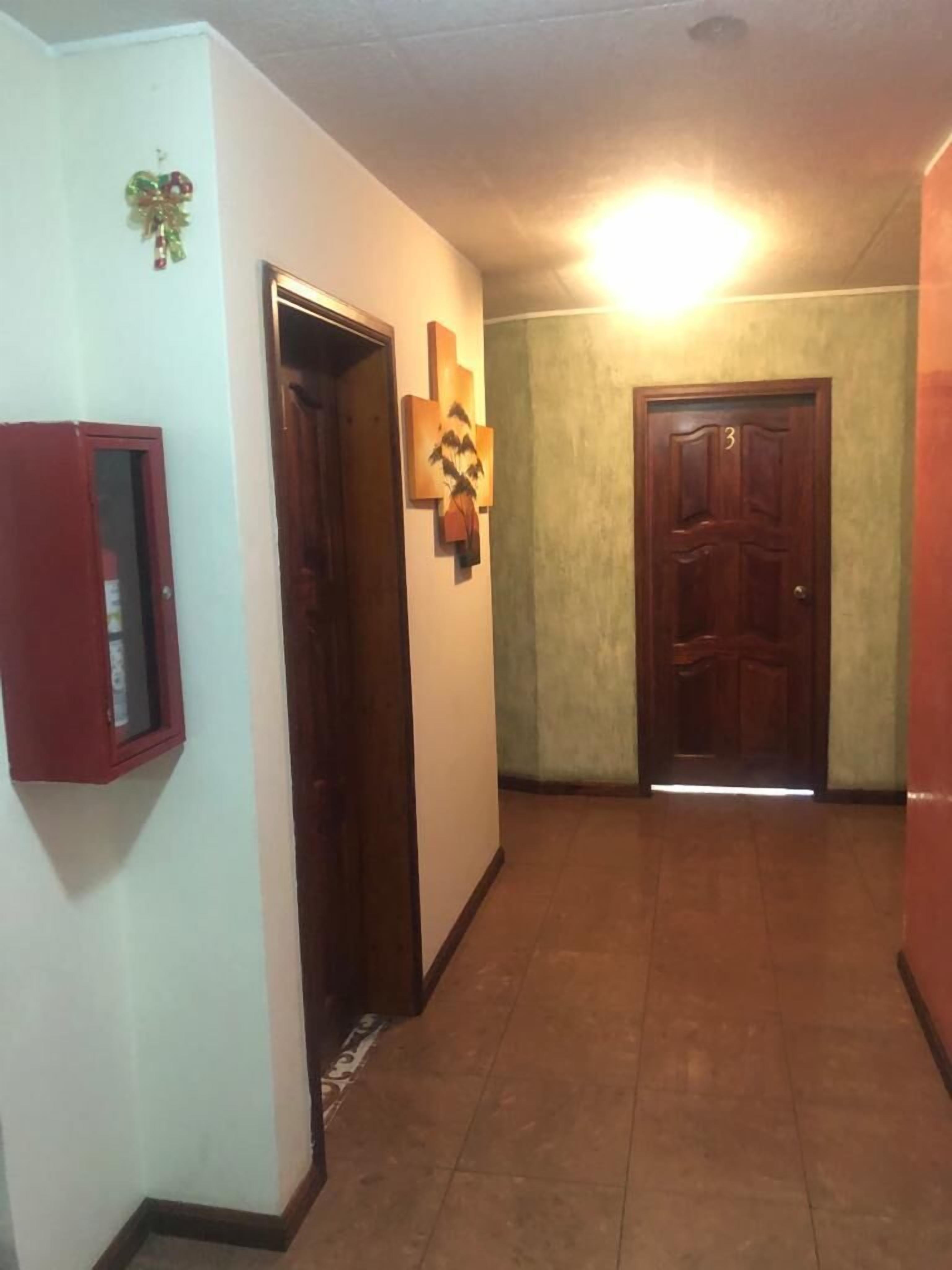 Un pasillo con una puerta de madera, un armario empotrado y una decoración en la pared.