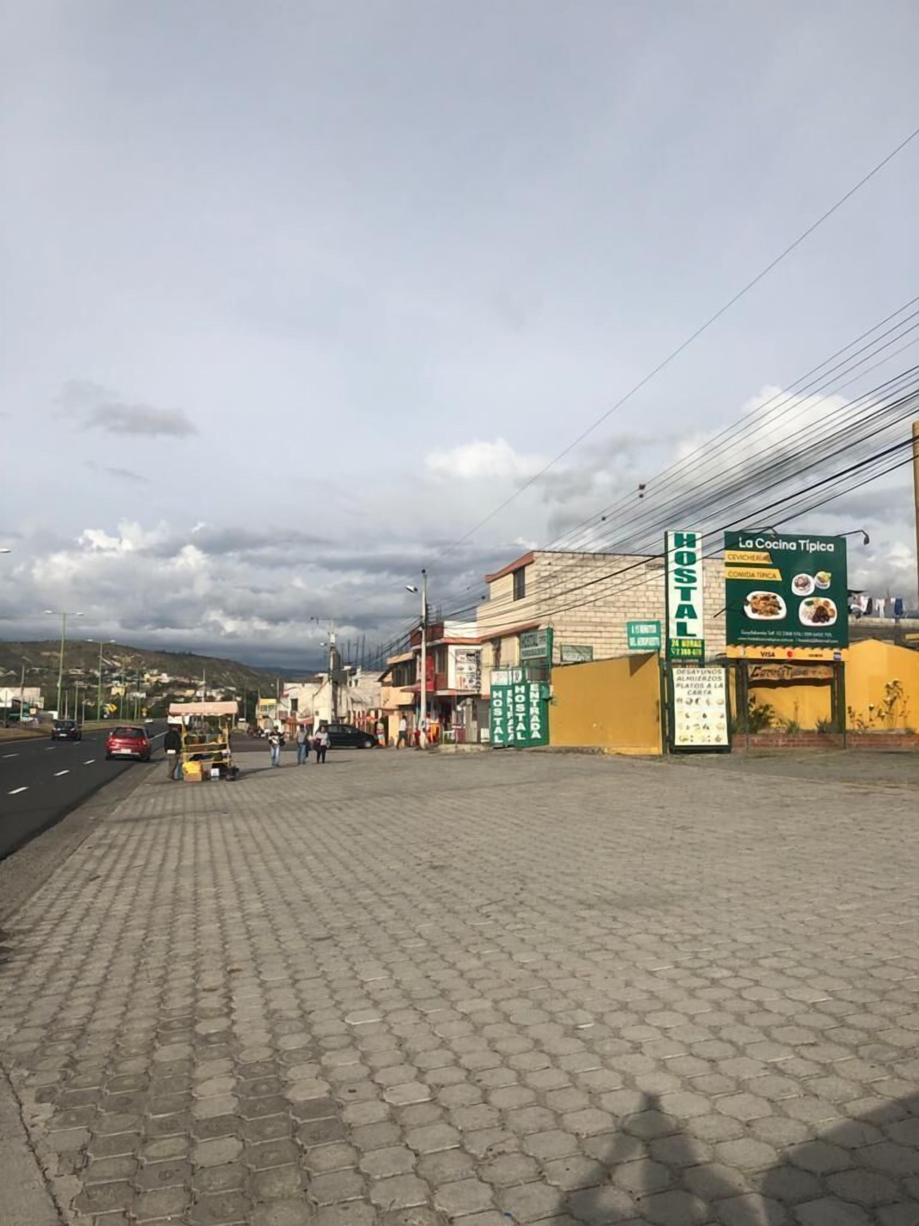 Une vue de rue avec une enseigne indiquant un « hostal » et le restaurant « La Cocina Típica ».