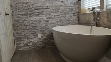 Bathtub, hair dryer, bathrobes, towels