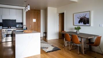 A modern kitchen with a central island, wooden cabinets, and stainless steel appliances.
