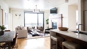 Una sala de estar moderna con un sofá, una mesa de centro y un comedor con una mesa y sillas de madera.