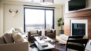 Una sala de estar moderna con un sofá, sillones, una mesa de centro y una chimenea.