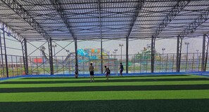 An indoor sports facility with a netted area and artificial turf. - Fantazia Marsa Alam Resort (Marsa Alam)