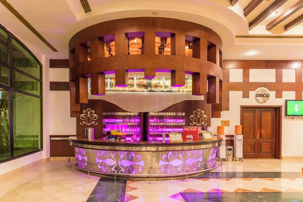 A bar area with a curved counter, shelves with bottles, and a 'DISCO' sign on the wall. - Fantazia Marsa Alam Resort (Marsa Alam)