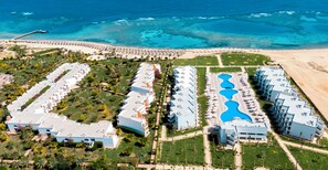 An aerial view of a resort with multiple buildings, a beach, and a large pool area. - Fantazia Marsa Alam Resort (Marsa Alam)